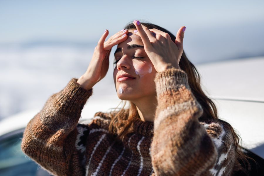 woman puts sunscreen on